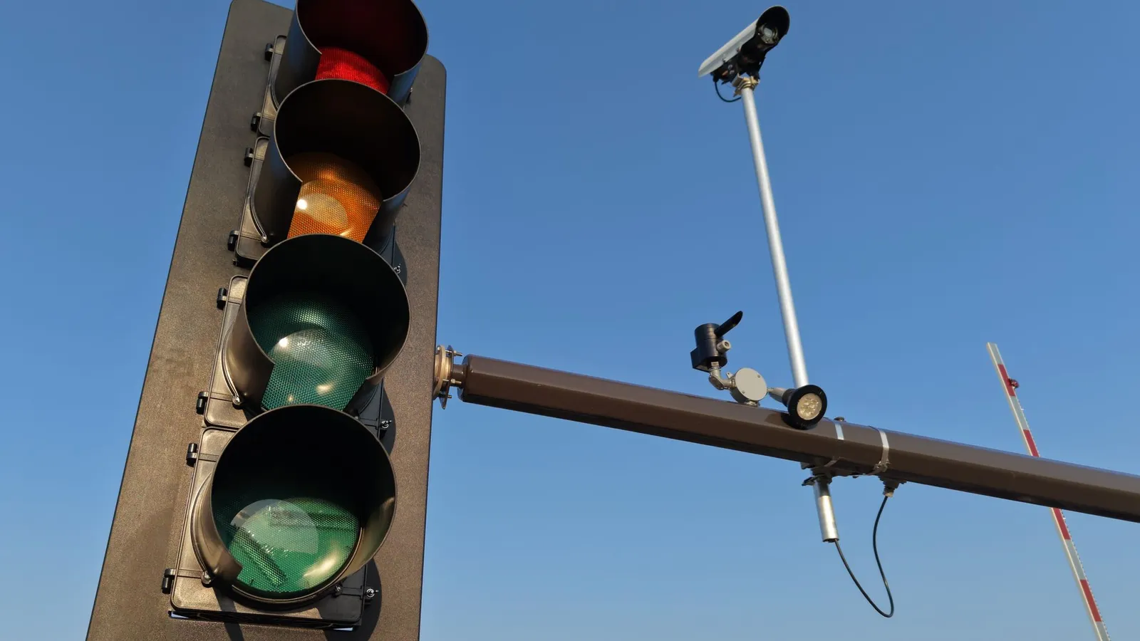 Semáforo y cámara de fotodetección sobre una avenida