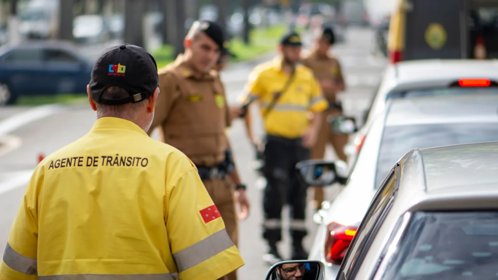 Agente de tránsito con chaleco amarillo regulando el tráfico en la calle