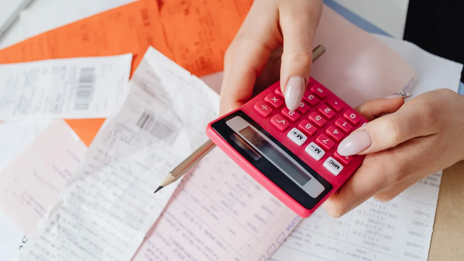 Persona revisando facturas con una calculadora