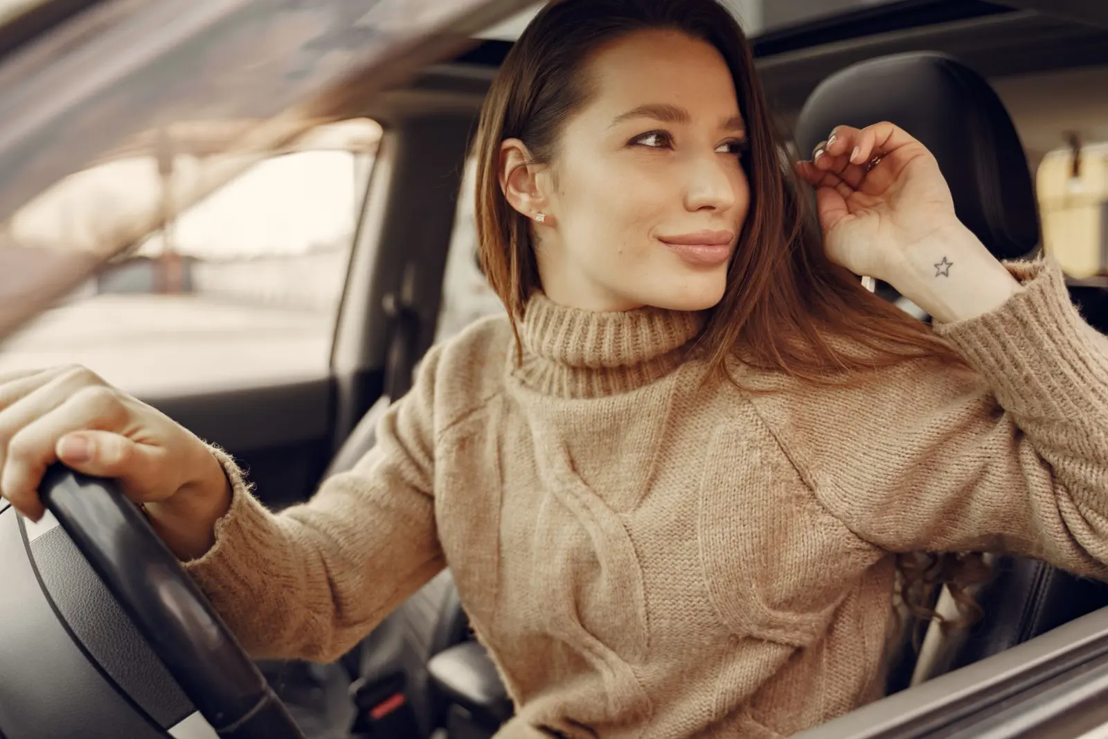Conductora sonriente al volante de su carro en la ciudad