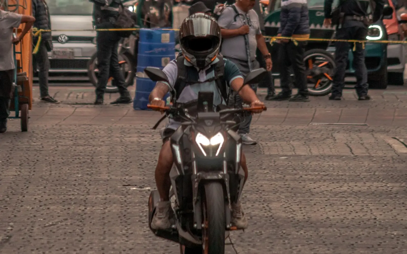 Motociclista con casco conduciendo por una calle de la ciudad